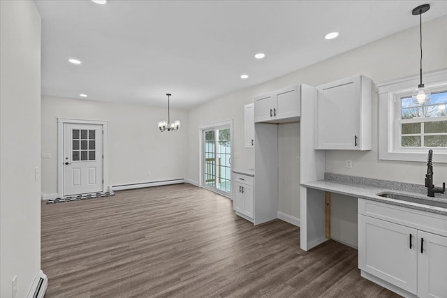 kitchen with white cabinets, decorative light fixtures, sink, and a baseboard radiator