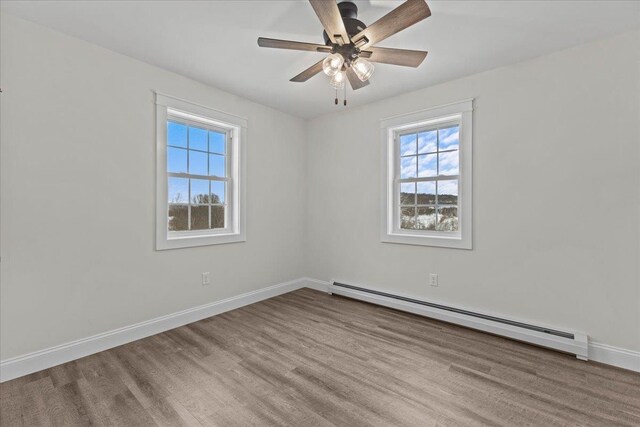 unfurnished room with baseboard heating, ceiling fan, and light hardwood / wood-style floors