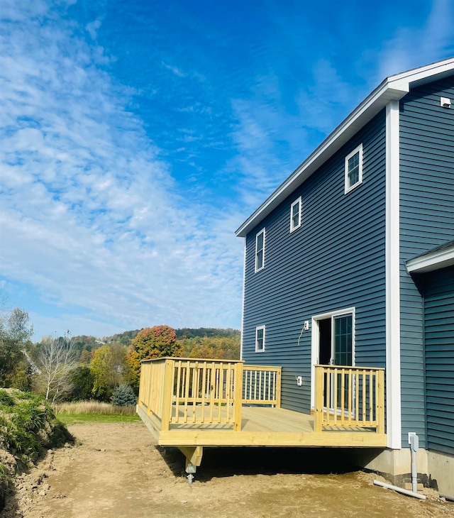 rear view of property featuring a wooden deck