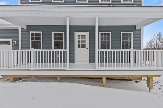 snow covered property entrance featuring a porch