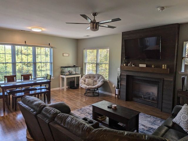 living room with wood-type flooring, a fireplace, and ceiling fan