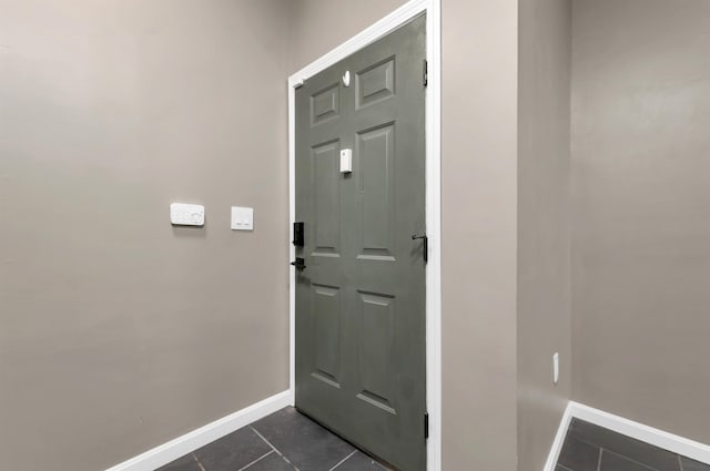 entryway with dark tile patterned floors