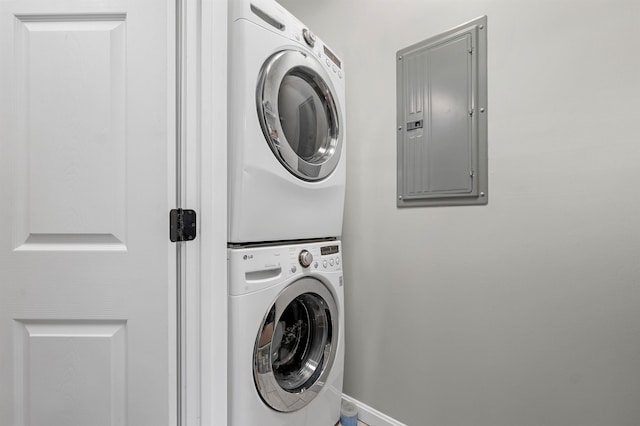 laundry room featuring stacked washer and clothes dryer and electric panel