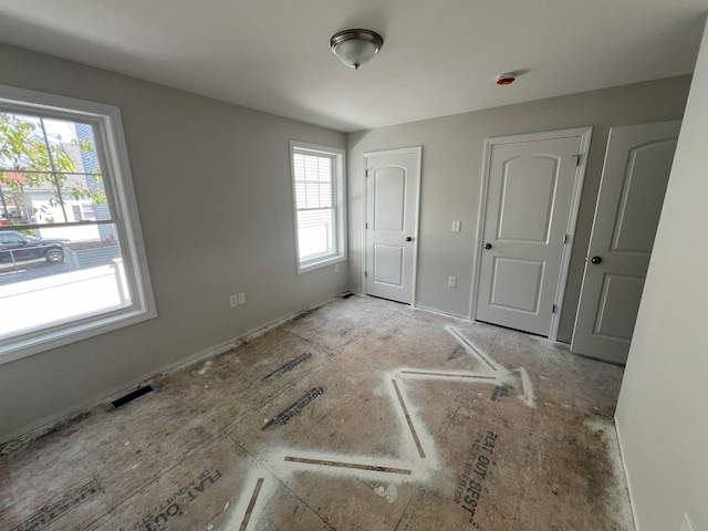 unfurnished bedroom featuring multiple windows