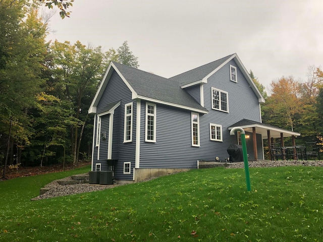 view of home's exterior with cooling unit and a lawn