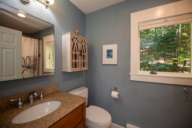 bathroom with a wealth of natural light, vanity, and toilet