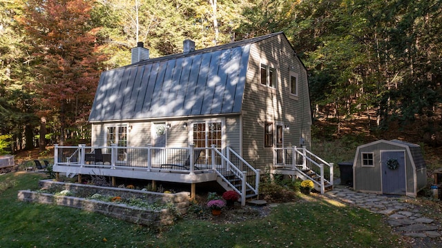 back of house featuring a wooden deck and a storage unit