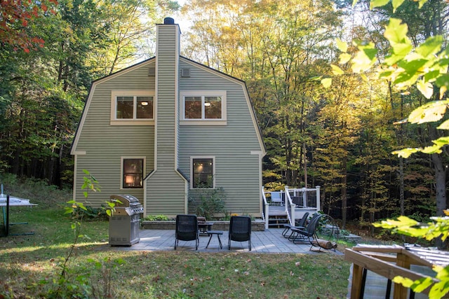 rear view of house featuring a lawn, a patio area, and a deck