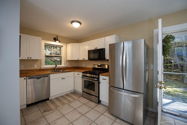 kitchen featuring butcher block counters, white cabinetry, sink, and stainless steel appliances