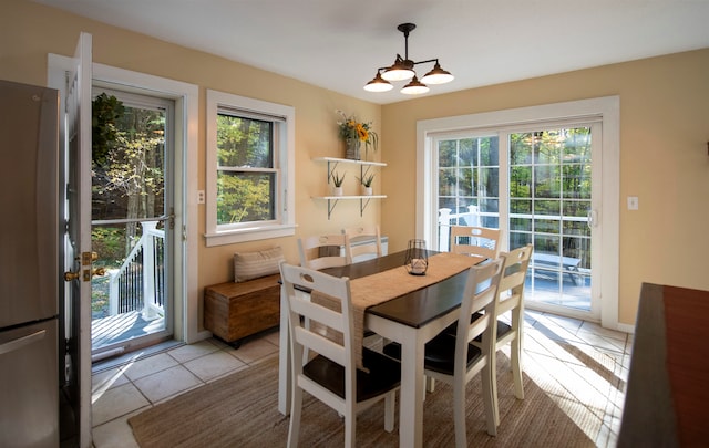 dining area featuring a notable chandelier, plenty of natural light, and light tile patterned floors