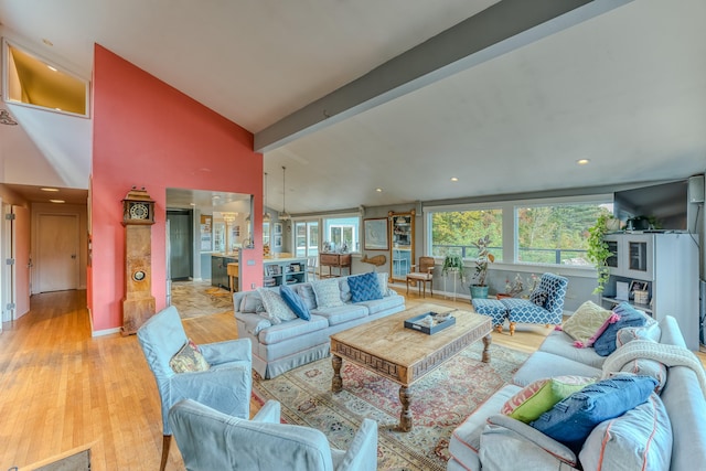 living room with vaulted ceiling with beams and light hardwood / wood-style floors