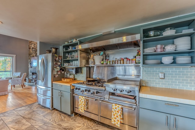 kitchen featuring decorative backsplash, light hardwood / wood-style floors, range hood, and appliances with stainless steel finishes