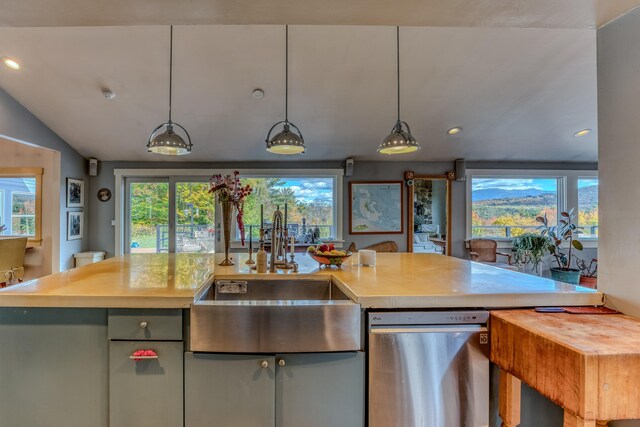 kitchen featuring lofted ceiling, sink, a kitchen island with sink, and decorative light fixtures