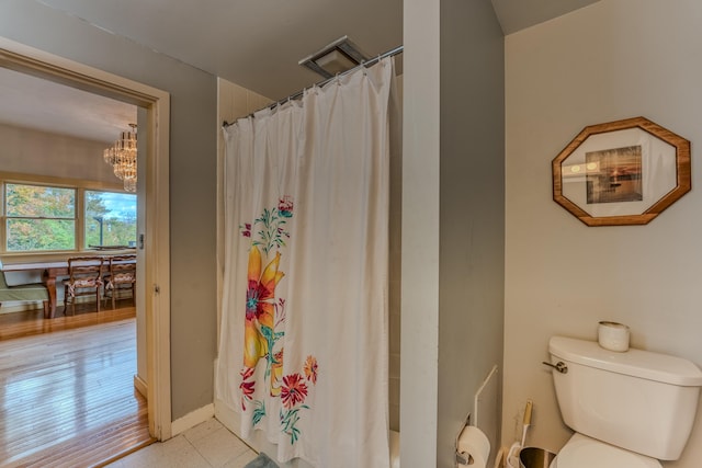 bathroom featuring curtained shower, toilet, a chandelier, and hardwood / wood-style flooring