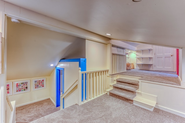 stairway with carpet and vaulted ceiling