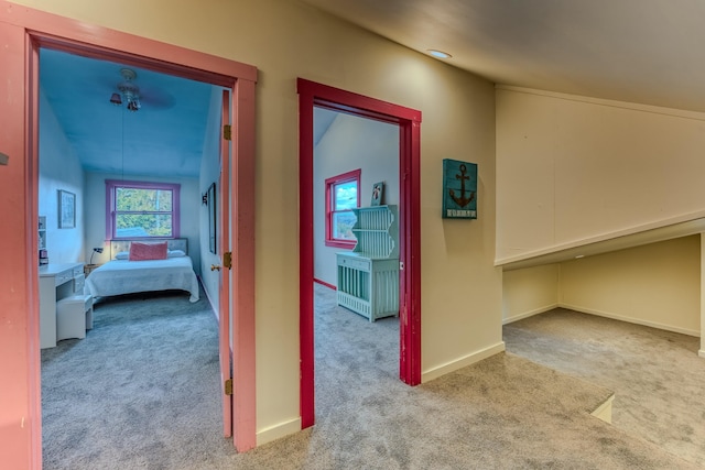 hallway with light carpet and lofted ceiling