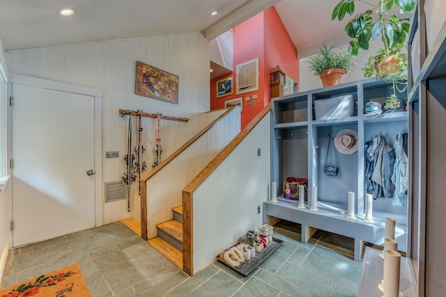 mudroom with wooden walls and lofted ceiling