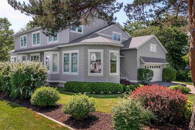 view of front of house featuring a garage and a front lawn