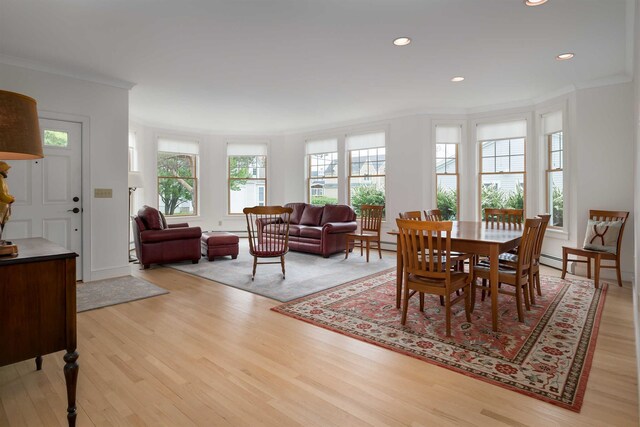 dining room with crown molding and light hardwood / wood-style flooring