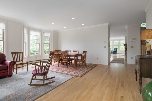 dining room with ornamental molding and light wood-type flooring