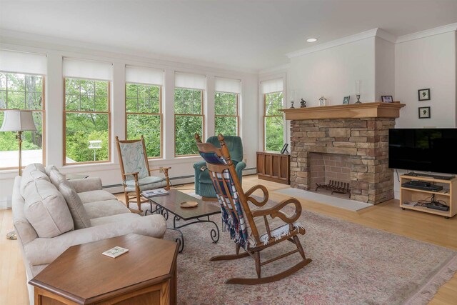 living room featuring ornamental molding, a stone fireplace, light hardwood / wood-style floors, and a baseboard radiator