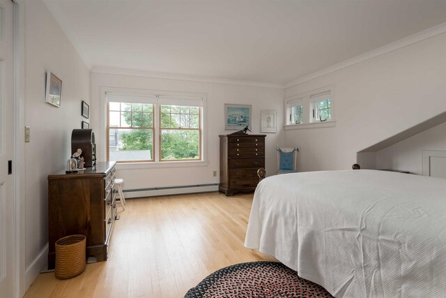 bedroom with a baseboard heating unit, ornamental molding, and light hardwood / wood-style floors