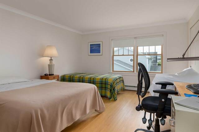 bedroom featuring crown molding and light hardwood / wood-style floors