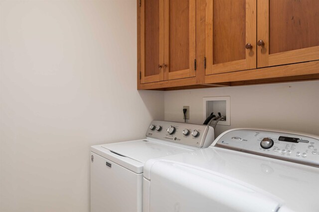 washroom featuring cabinets and washing machine and clothes dryer