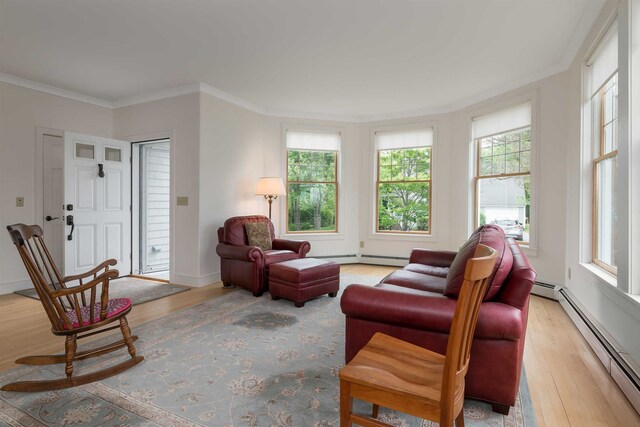 living room with light hardwood / wood-style flooring, ornamental molding, a healthy amount of sunlight, and baseboard heating