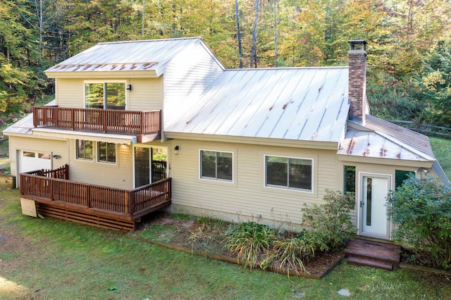 back of house featuring a balcony, a deck, and a lawn