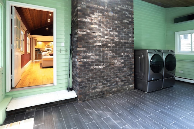 washroom with wood ceiling, dark hardwood / wood-style floors, washing machine and clothes dryer, and brick wall