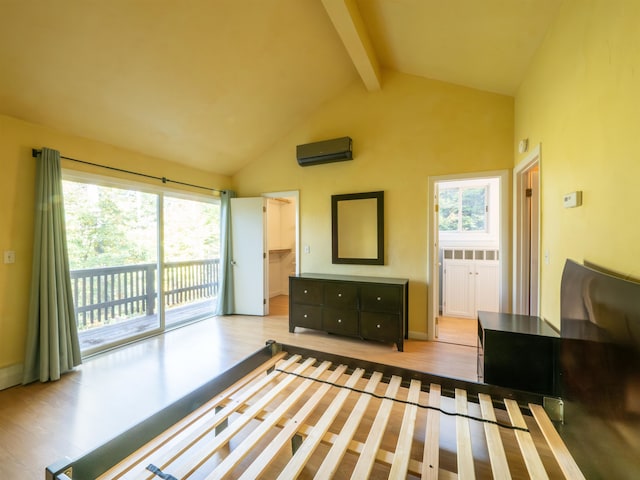 interior space featuring an AC wall unit, light hardwood / wood-style floors, beamed ceiling, and high vaulted ceiling