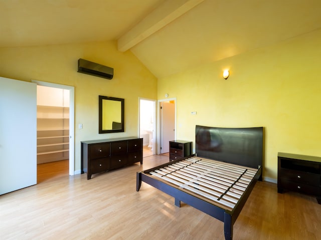 bedroom featuring a wall unit AC, a closet, a spacious closet, and light hardwood / wood-style flooring