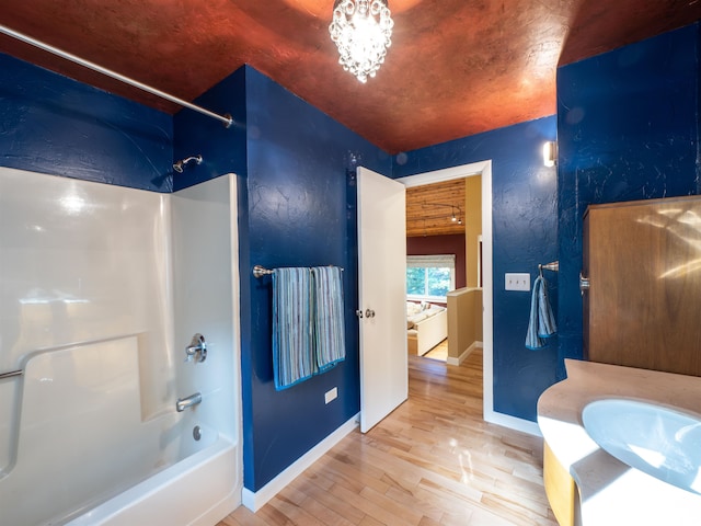 bathroom with wood-type flooring,  shower combination, and vanity