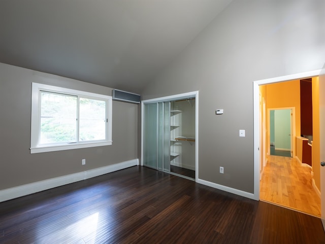 unfurnished bedroom with a closet, dark hardwood / wood-style flooring, and high vaulted ceiling