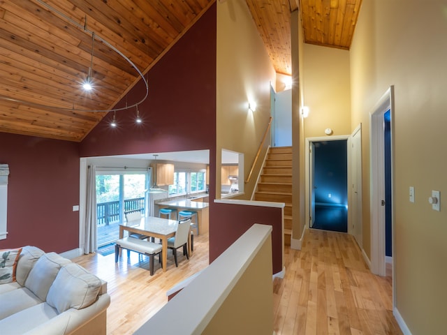 hall featuring wood ceiling, high vaulted ceiling, and light hardwood / wood-style flooring