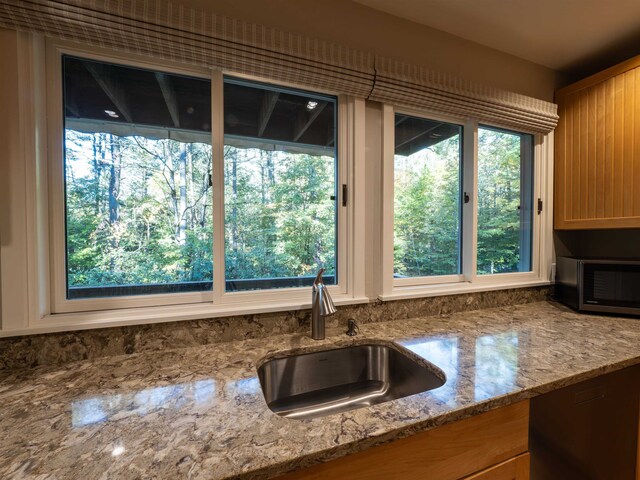 kitchen with light stone countertops and sink