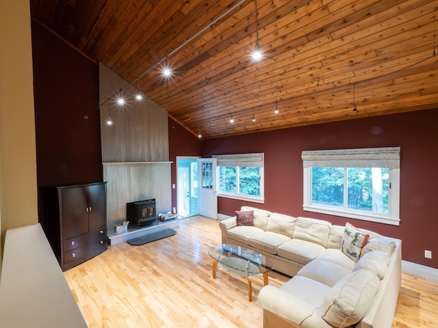 living room featuring wood ceiling, a wood stove, high vaulted ceiling, and light hardwood / wood-style flooring