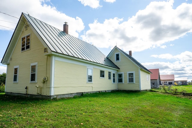 rear view of house featuring a yard