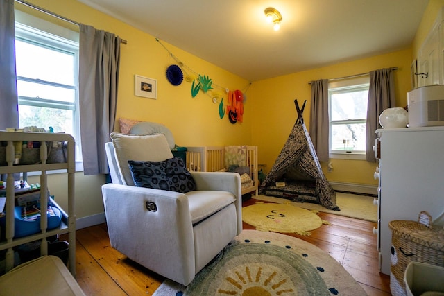 sitting room featuring baseboard heating and hardwood / wood-style floors