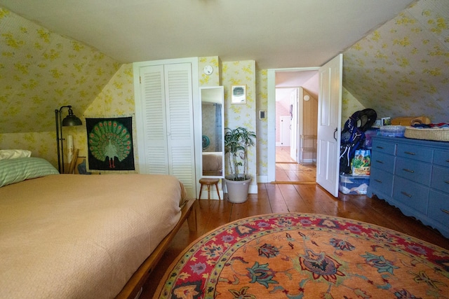 bedroom featuring vaulted ceiling, a closet, and dark hardwood / wood-style flooring