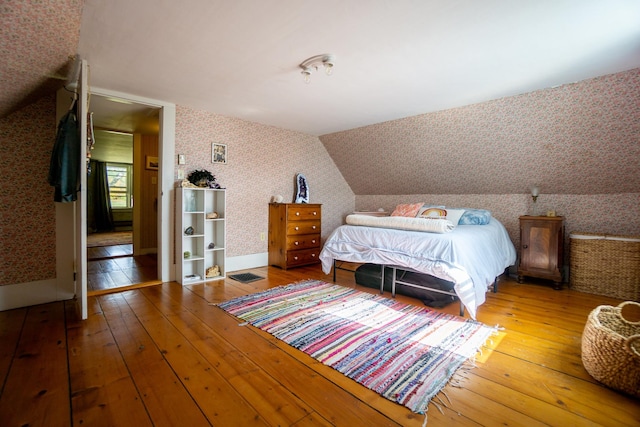 bedroom with wood-type flooring and lofted ceiling