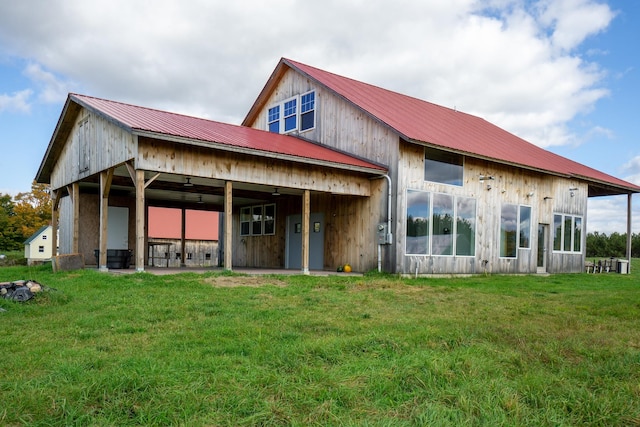 back of property featuring ceiling fan and a yard