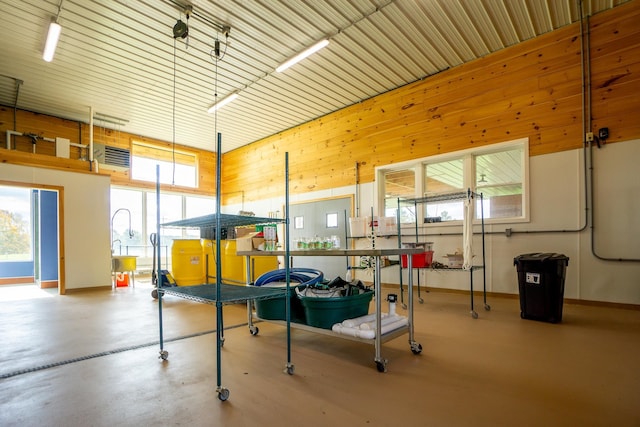 interior space with concrete floors, wood walls, and a towering ceiling