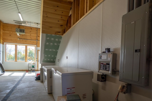 laundry room with electric panel, wood walls, and a high ceiling