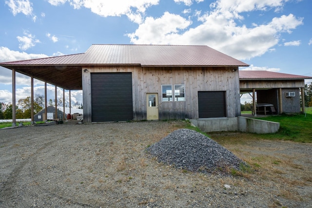 garage featuring wooden walls and a carport