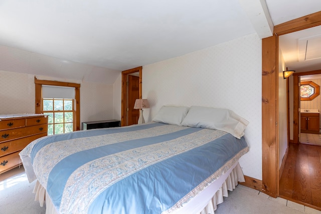 bedroom with light hardwood / wood-style flooring and ensuite bath