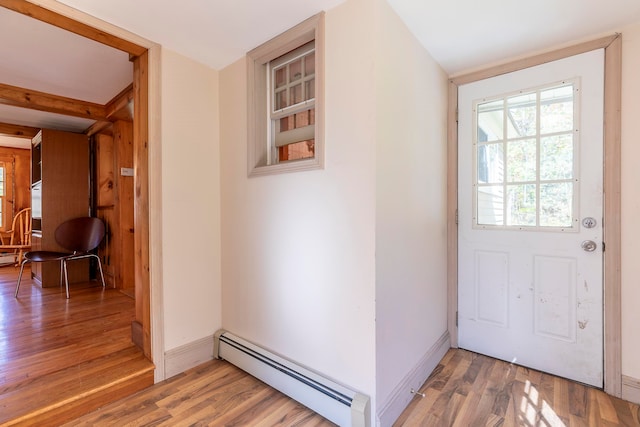 doorway with hardwood / wood-style floors and a baseboard heating unit