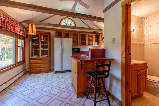 kitchen with a kitchen breakfast bar, white refrigerator, a healthy amount of sunlight, and baseboard heating