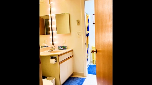 bathroom featuring vanity, tile patterned flooring, and toilet